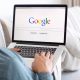 Pessoa com o notebook no colo acessando o Google