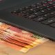 imagem de um negócio online, representado por um notebook que entrega dinheiro
