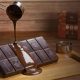 Imagem de uma colher derramando chocolate sobre uma barra de chocolate