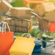 Miniatura de carrinho de supermercado com compras em cima de um notebook