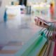 Mulher segurando sacolas de compras e um smartphone