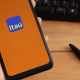 Imagem de uma mão de pessoa branca segurando smartphone com o aplicativo do Itaú na tela